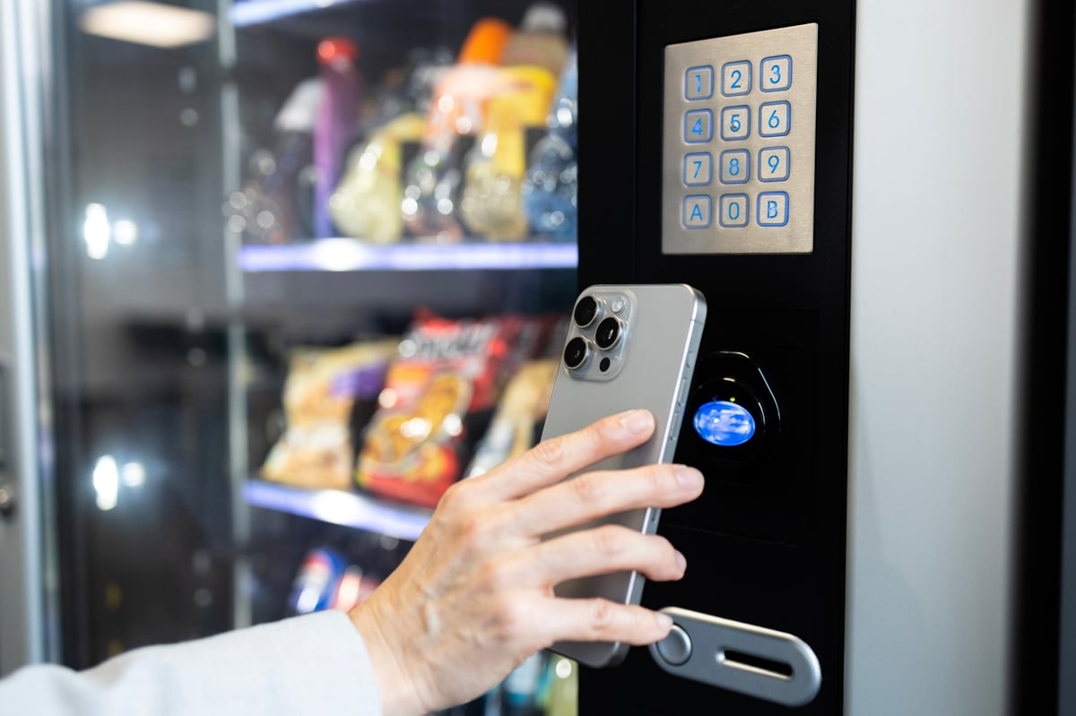 Woman making a contactless payment at a vending machine